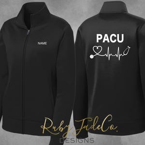 May include: Black fleece jacket with a zipper closure. The left side of the jacket has the word "NAME" embroidered on the chest. The right side of the jacket has the text "PACU" and a heart with a stethoscope and a heartbeat line.