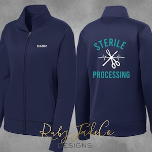 May include: Navy blue fleece jacket with a zipper closure. The back of the jacket has the text "STERILE PROCESSING" with a heart beat line and a pair of scissors. The front of the jacket has the text "name" in white.