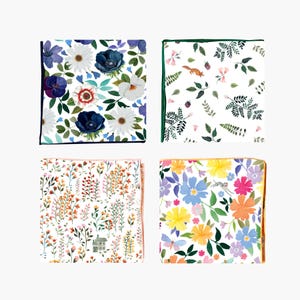 Peut inclure: Quatre mouchoirs carrés avec des motifs floraux et naturels. Les motifs comprennent des marguerites blanches, des anémones bleues, un renard, des fleurs sauvages et des papillons. Chaque mouchoir a une bordure colorée : noir, vert, pêche et orange.