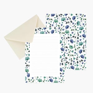 May include: A stationery set featuring a cream-coloured envelope and two sheets of paper decorated with a pattern of blue and green ginkgo leaves. One sheet is lined for writing, while the other displays the full botanical leaf print design.