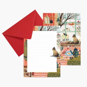 May include: A stationery set comprising a red envelope, lined writing paper, and illustrated artwork. The artwork shows a winter scene with cats, a table setting, and a snowy landscape viewed through a window.