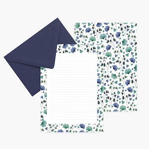 Peut inclure: Un ensemble de papeterie comprenant une enveloppe bleu marine, du papier à lettres ligné et une feuille à motifs. Le papier et la feuille à motifs ont un fond blanc avec un motif répété de feuilles et de tiges bleues et turquoise.