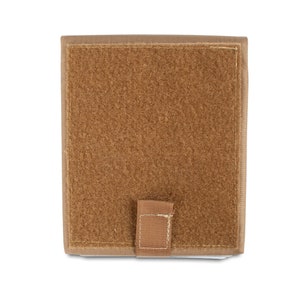 May include: A tan-colored, rectangular pouch with a hook and loop closure. The pouch has a brown velcro panel on the front.