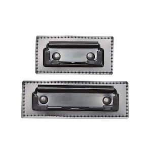 May include: Two black leather document holders with metal clips. The larger holder is on the bottom and the smaller holder is on top.