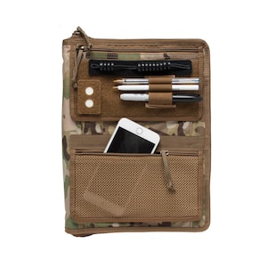 May include: A brown and green camouflage zippered binder with a mesh pocket, a zippered pocket, and a clear plastic pocket with a black elastic band. The binder has a white phone in the mesh pocket and pens in the clear plastic pocket.