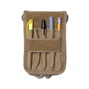 May include: A tan zippered pouch with four slots for pens and pencils. The pouch has a velcro strap and is made of a durable fabric.
