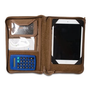 K&ouml;nnte beinhalten: Eine ge&ouml;ffnete braune Rei&szlig;verschlusstasche mit einem Taschenrechner, einer durchsichtigen Plastiktasche mit einer Visitenkarte, einer durchsichtigen Plastiktasche mit einer Karte und einem Tablet in einem schwarzen Etui.