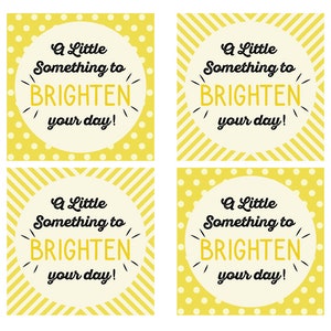 Op de afbeelding: Vier gele cadeau-etiketten met witte stippen en gele strepen. Elk etiket heeft een witte cirkel met de tekst "A Little Something to BRIGHTEN your day!" in zwart.