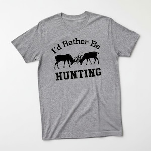 A gray t-shirt with a graphic design featuring two deer heads and the text "I'd Rather Be HUNTING" printed on it.