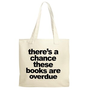 A beige tote bag with the text "there's a chance these books are overdue" printed on it.