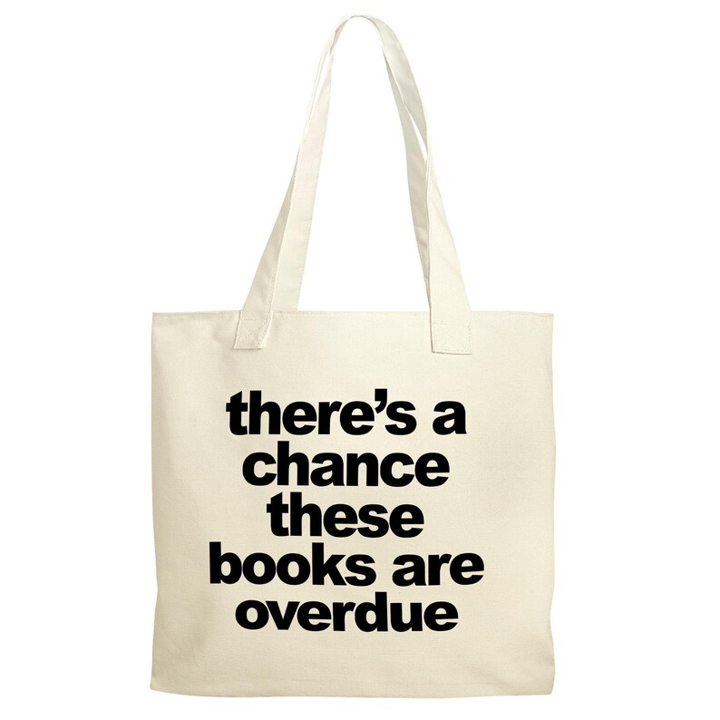 A beige tote bag with the text "there's a chance these books are overdue" printed on it.