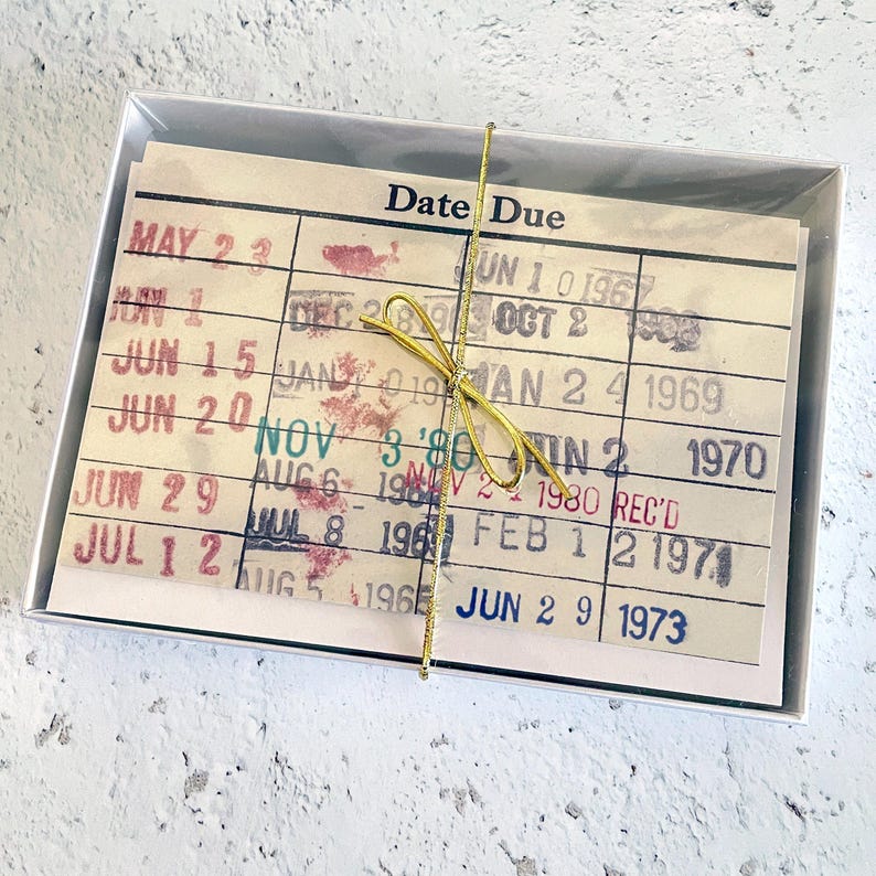A white box containing a stack of yellowed, handwritten date due cards.