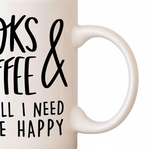 A white mug with black text that says "I need coffee and books to be happy".
