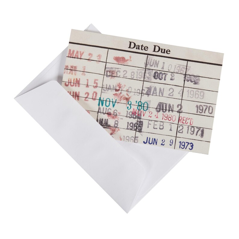 a white envelope with a date due card attached to it, which appears to be a library receipt or library card.