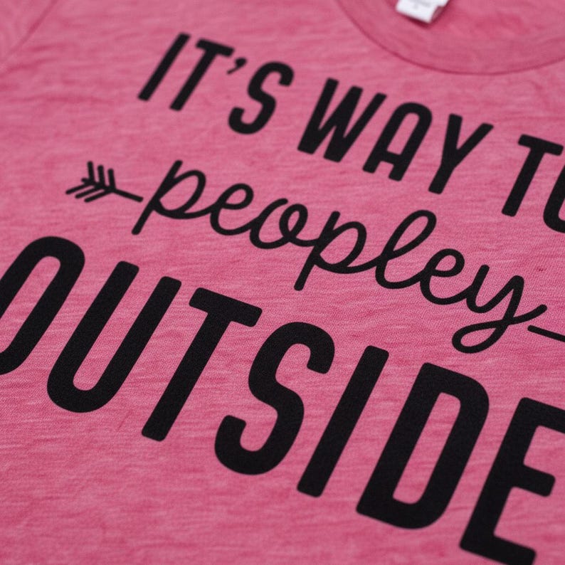 A pink t-shirt with black text that reads "IT'S WAY TO PEOPLEY OUTSIDE".