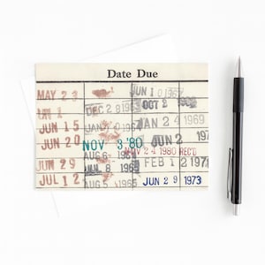 a date due card with a pen next to it, placed on a white background.