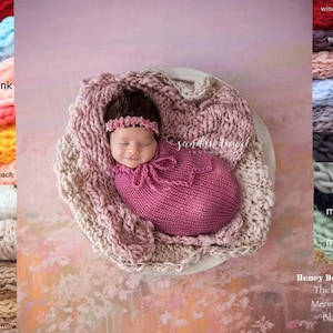 May include: A newborn baby wearing a pink knitted wrap and a pink headband is lying in a large, light pink knitted bowl. The bowl is sitting on a light pink and orange textured background. The image includes a color chart of different knitted wraps and a sign that reads "Honey Dew Props, Thick n Thin, Merino Bump, Blanket."