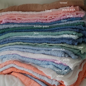 May include: A stack of 16 different coloured fabric squares, including peach pink, hunter green, baby blue, periwinkle, white, and mandarin. The fabric squares are arranged in a gradient from light to dark.