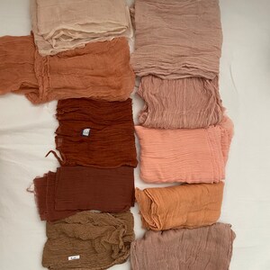 Pu&ograve; includere: Una collezione di dieci quadrati di tessuto in varie tonalit&agrave; di marrone, rosa e beige. Il tessuto &egrave; morbido, leggero e ha una texture leggermente stropicciata.