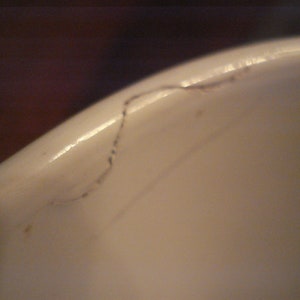 May include: Close-up of a white ceramic surface with a thin black line running across it.