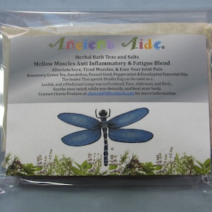 May include: A white muslin bag with a blue dragonfly illustration and green foliage at the bottom. The bag is labeled "Ancient Aide" and contains herbal bath teas and salts for muscle and joint pain relief. The text reads "Mellow Muscles Anti Inflammatory & Fatigue Blend Alleviate Sore, Tired Muscles, & Ease Your Joint Pain Rosemary, Green Tea, Dandelion, Fennel Seed, Peppermint & Eucalyptus Essential Oils The Sealed Therapeutic Muslin Bag can be used as a Loofah, and a Medicinal Compression Forehead, Face, Abdomen, and Body.. Soothe your mind, while you detoxify, and heal your body. Contact Cherie Poulsen at cheuoa49@outlook.com for more information."