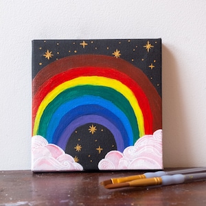 ¡Pintura acrílica original del arcoíris con nubes y estrellas doradas y brillantes para alegrar tu día! Pintura de colores sobre lienzo negro.
