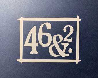 May include: White handwritten numbers 46 and 2 with an ampersand symbol in between, all enclosed in a white square frame on a dark blue background.