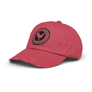 May include: A red distressed baseball cap with a black and white circular graphic that says "Ain't Found a Way to Kill Me Yet" with a chicken silhouette inside the circle.