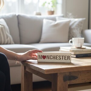 Könnte beinhalten: Ein Set aus drei Keramikbechern mit gesprenkelter, matter Oberfläche. Die Becher sind in den Farbtönen Creme, Hellgrau und Dunkelgrau gehalten. Jeder Becher hat ein schlichtes, minimalistisches Design und einen abgerundeten Henkel.