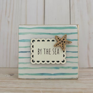 By the sea wood sign