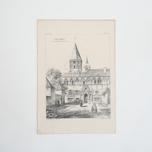 May include: An antique black and white print of a European cathedral. The print features the text "Corey Abbey" at the top, with detailed architectural elements, including a tall spire and arched windows. Figures are walking in front of the building.