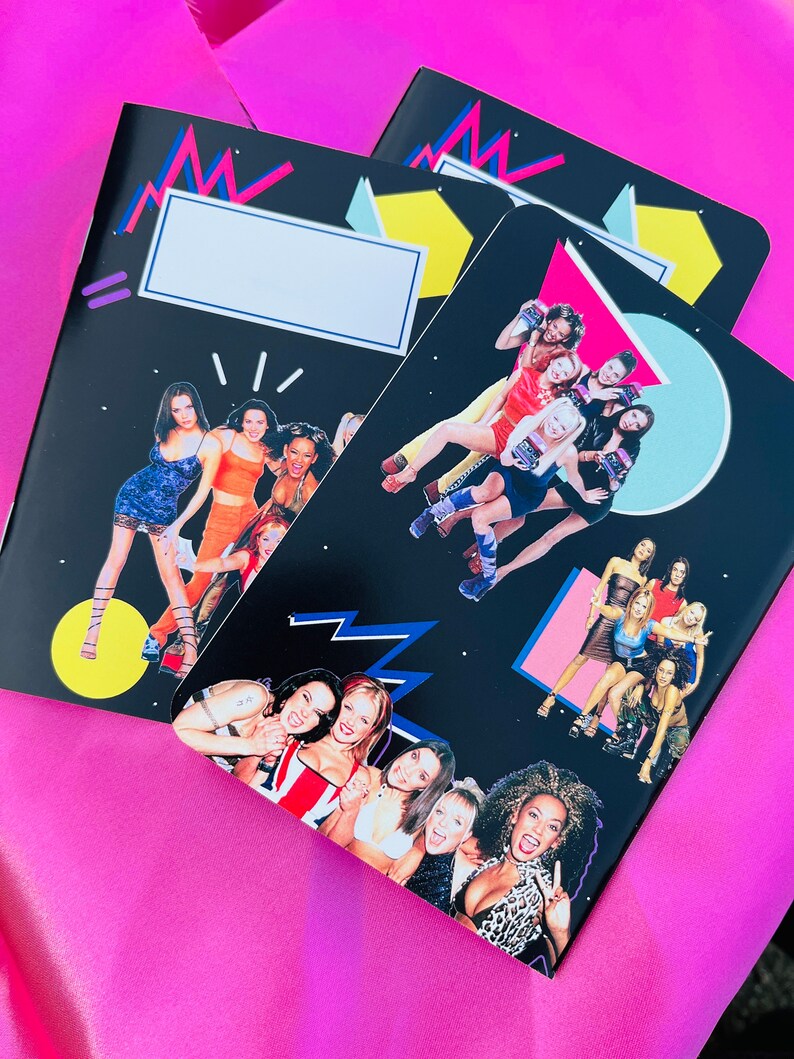 K&ouml;nnte beinhalten: Drei schwarze Notizb&uuml;cher mit farbenfrohen geometrischen Designs und Bildern einer Popmusikgruppe. Die Notizb&uuml;cher haben einen wei&szlig;en rechteckigen Bereich f&uuml;r einen Namen oder Titel. Der Hintergrund ist hellrosa.