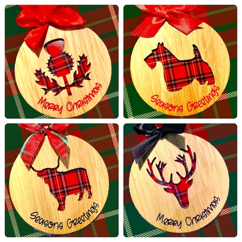 May include: Four round wooden ornaments with red and black plaid designs. The ornaments feature a thistle, a terrier, a highland cow, and a reindeer. The ornaments are decorated with the text "Merry Christmas" and "Seasons Greetings".