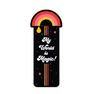 Peut inclure: Un marque-page noir avec un arc-en-ciel, des étoiles et le texte "My World is Magic!" dans une police rétro.