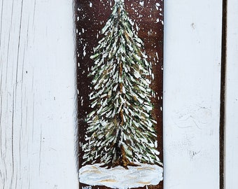 Snow covered spruce tree on rusty metal