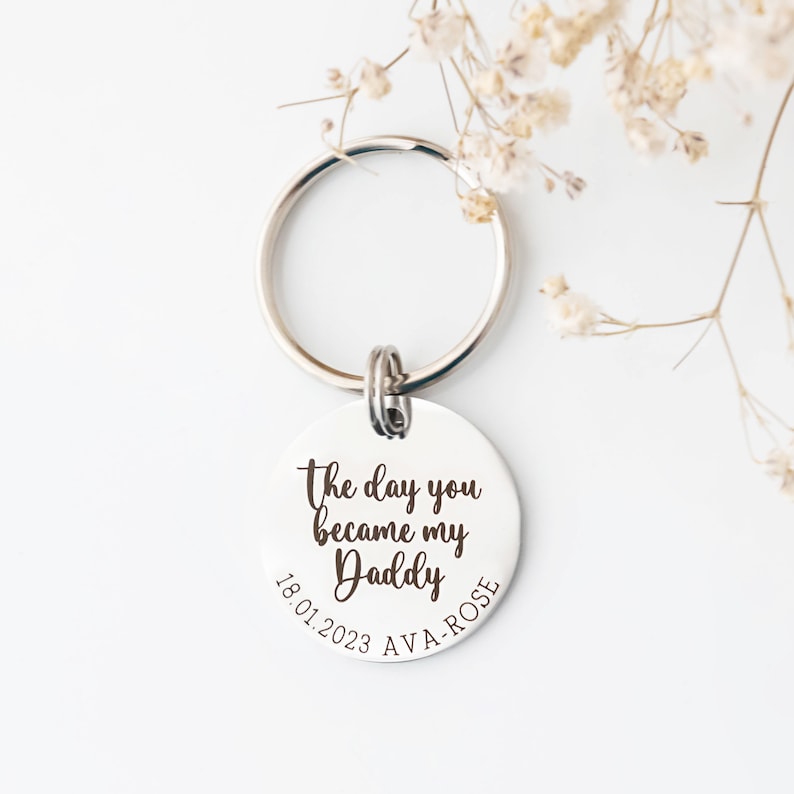 30mm stainless steel engraved keyring. Text reads The day you became my Daddy and is customisable with a child's name and date of birth around the bottom curve of the disc.