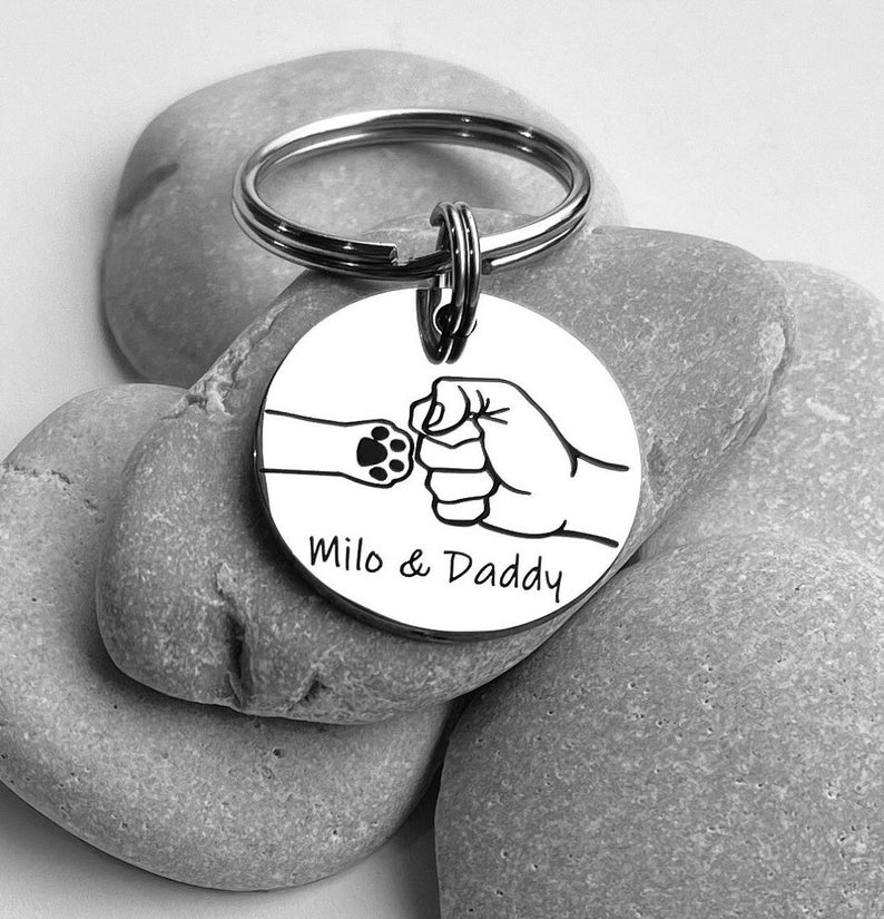 Stainless steel personalized engraved dog paw and fist bump keychain.