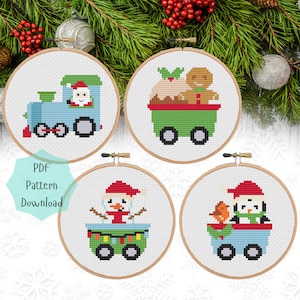 May include: Four Christmas-themed cross-stitch patterns featuring a train with Santa, a snowman, a penguin, and a gingerbread man with a Christmas pudding. Each pattern is displayed in a round embroidery hoop.