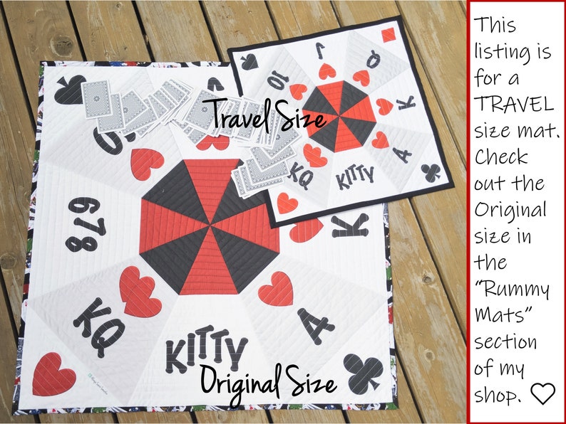 May include: Two quilted game mats, one labeled "Travel Size" and the other "Original Size". Both mats feature a black and red umbrella design with playing card symbols and numbers. The mats are made of white fabric with black and red quilting.