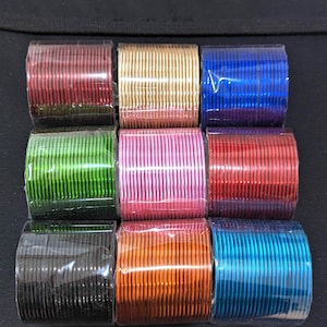 May include: A set of ten colorful metal bangles, packaged in clear plastic. The bangles are arranged in two rows of five, with each row featuring a different color: red, gold, blue, green, pink, red, black, orange, blue, and turquoise.