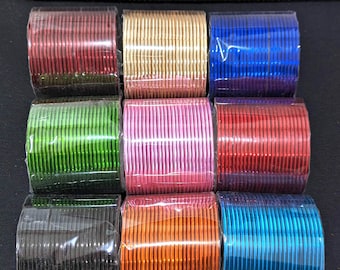 May include: A set of ten colorful metal bangles, packaged in clear plastic. The bangles are arranged in two rows of five, with each row featuring a different color: red, gold, blue, green, pink, red, black, orange, blue, and turquoise.
