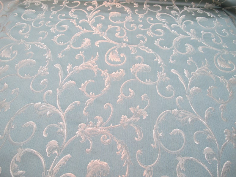 May include: A light blue fabric with a white damask pattern of swirling vines and leaves.