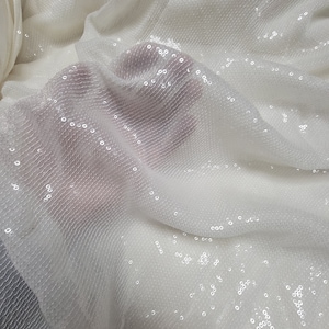 May include: White sheer fabric with small, white sequins. The fabric is textured and has a subtle sheen.