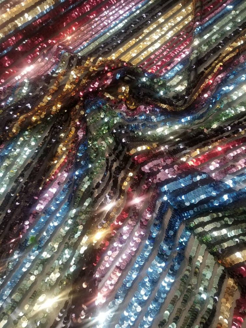 54 wide. Multicolored striped sequences fabric usable for apparel accessories and interior designs