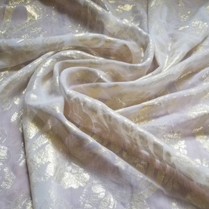 100% Silk chiffon metallic floral design. Rich and beautiful gold mettallic floral on off white silk chiffon to create formal and evening we