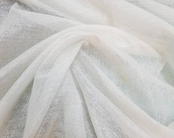 May include: White sheer fabric with a fine, woven texture. The fabric is draped and folded, showing its delicate and airy quality.