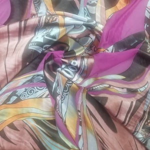 Pode incluir: Um tecido estampado em rosa, marrom e amarelo com um design geom&eacute;trico. O tecido &eacute; feito de um material macio e sedoso.