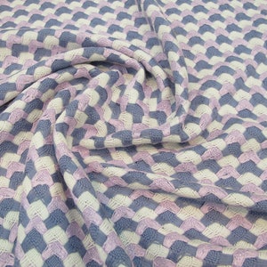 May include: A woven fabric with a geometric pattern in shades of white, light purple, and blue.