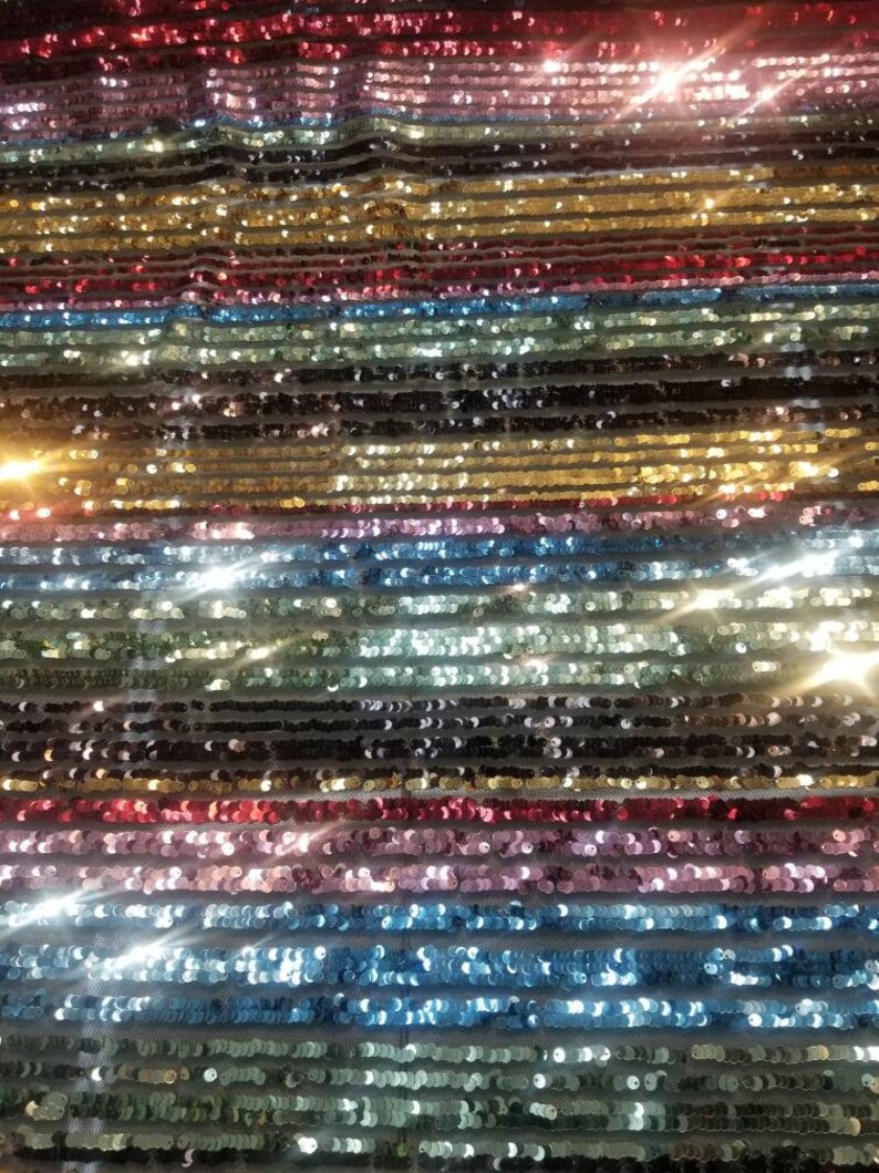 54 wide. Multicolored striped sequences fabric usable for apparel accessories and interior designs