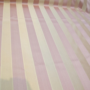 May include: A fabric with alternating stripes of light pink and cream.